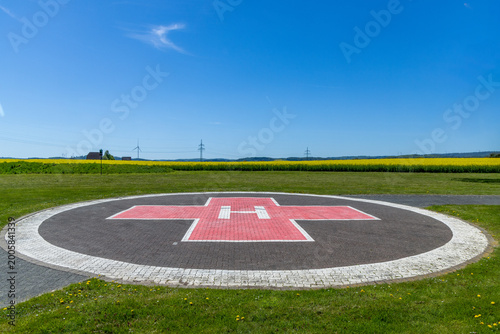 Tableau sur toile Helicopter landing port in the landscape near a hospital with yellow rape field