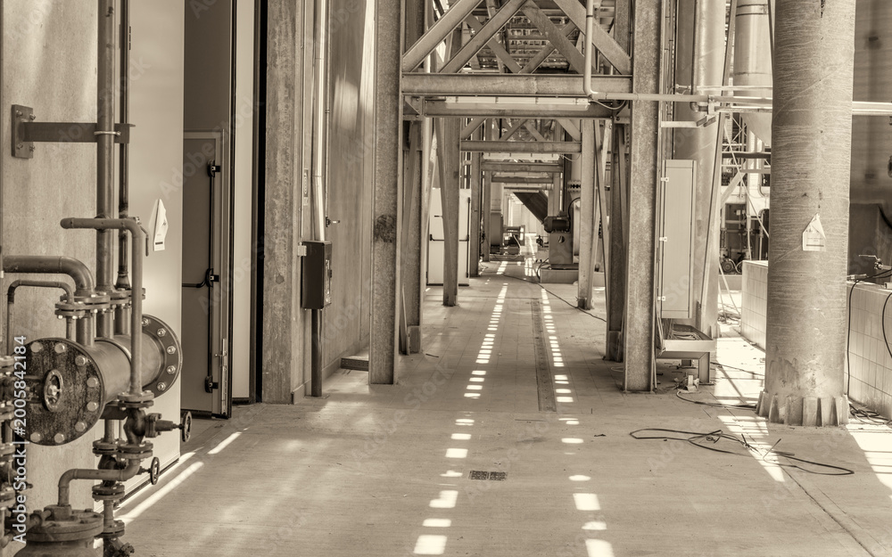 Fototapeta premium Large unfinished industrial space featuring metal beam framework and raw warehouse construction interior details