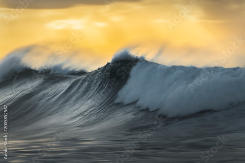 Abstract blurred image of rising sun creating glowing yellow and orange light gradient sky with soft artistic effect at sunrise, Sydney, Australia.