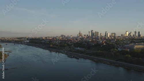 Breathtaking drone shots from Warsaw's Praga side of the Vistula capture sunset glow over the skyline. Golden light bathes bridges, rivers, and cityscape in warm hues