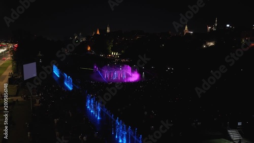 Stunning night drone footage captures Warsaw's magical glow over the Vistula. Park Fontann's lights dance on water, illuminating bridges and skyline in cinematic aerial sweeps