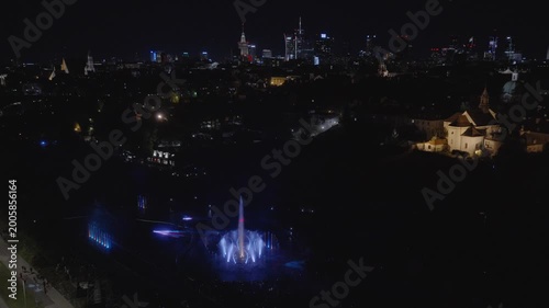Stunning night drone footage captures Warsaw's magical glow over the Vistula. Park Fontann's lights dance on water, illuminating bridges and skyline in cinematic aerial sweeps
