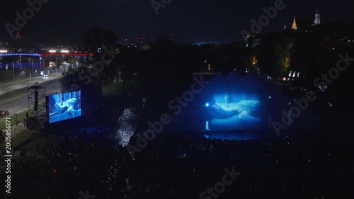 Stunning night drone footage captures Warsaw's magical glow over the Vistula. Park Fontann's lights dance on water, illuminating bridges and skyline in cinematic aerial sweeps