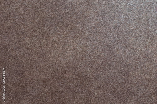 Fotografia An earthy brown background features a subtle granular and finely textured surface