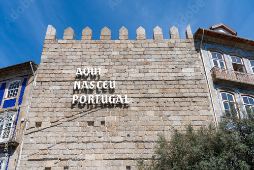 Aqui Nasceu Portugal sign on a stone tower wall in Guimaraes