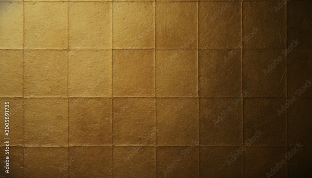 Fototapeta premium A close-up of a luxurious gold leaf panel with a grid-like texture, displaying subtle variations in light and shade across its surface.