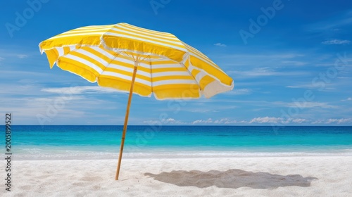 Vibrant Yellow Striped Umbrella on a Pristine White Sand Beach with Turquoise Ocean and Blue Sky.