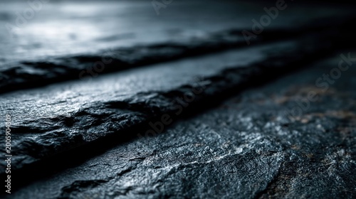 A dark, textured stone surface features prominent rough lines and grungy details, creating an abstract and moody background. The natural material exhibits a rugged pattern with varying shades of gray.