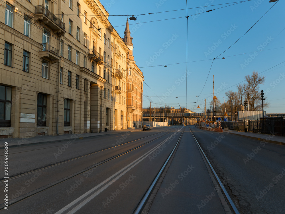Obraz premium Serene city avenue illuminated by golden sunlight during quiet hours