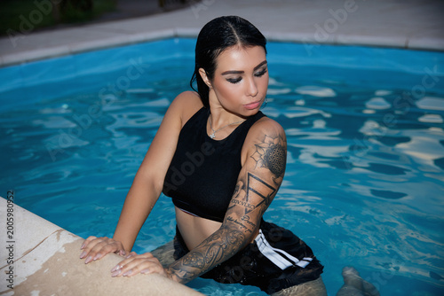 Young sexy brunette sitting in the pool