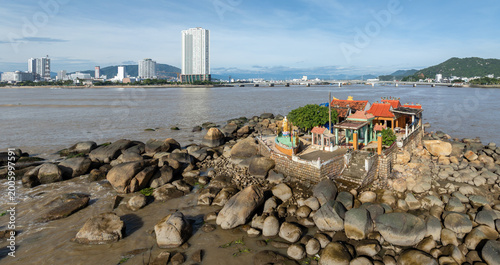 Fényképezés A scenic view of the Nha Trang coastline in Vietnam, featuring Mieu Ong temple on rocky outcrops with the city skyline in the background