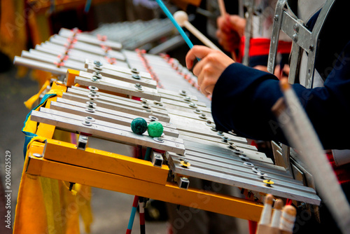 Marching band glockenspiel performance in outdoor parade with natural light