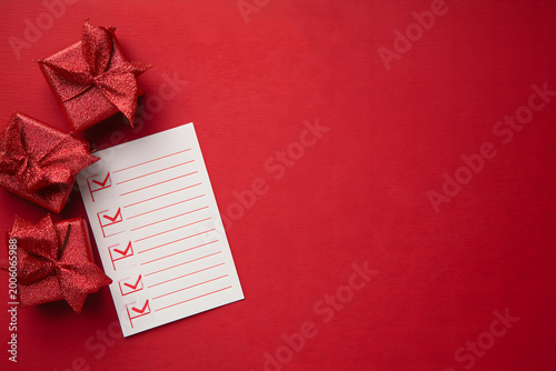 a holiday wish list, office notes with gift boxes isolated on red background