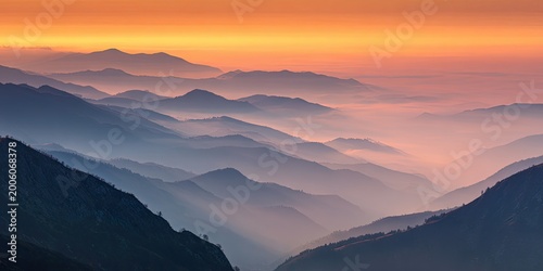 Layered misty mountains bathed in warm sunset hues