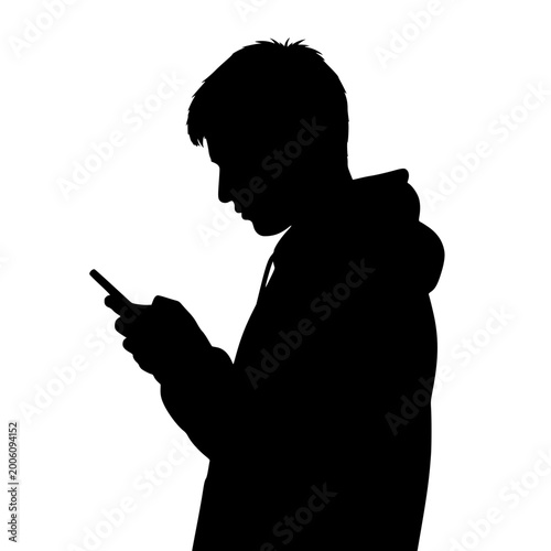 Silhouette of a young man wearing a hoodie using a smartphone