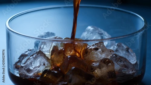 Ice cubes with coffee splash on blue background refreshing cold drink concept extreme close up macro