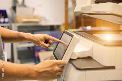 Office men use photocopy or copier machine at workplace is equipment for make a copy paper or photocopier for scanning document and photocopying service maintenance concepts.
