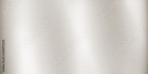 A polished silver stainless steel plate features a smooth brushed metal texture with a shiny metallic gray surface and light reflections on a seamless aluminium backdrop pattern