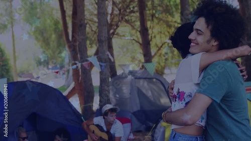 smiling hug starting, camping couple embracing, turning, animated flags highlighting guitar, tents