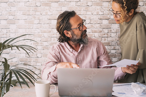 Fotografie Two people engaging in a constructive business discussion, reviewing documents a