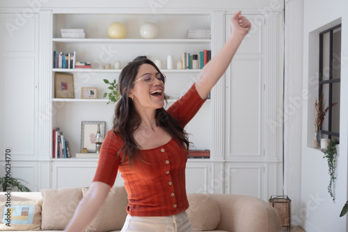 Foto Woman feeling cheerful and expressing elation with a raised arm, enjoying a mome