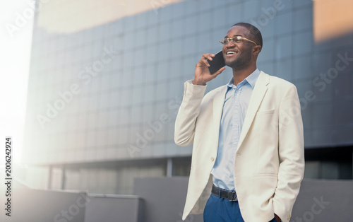 African american man talking on smartphone on street in city outdoor.