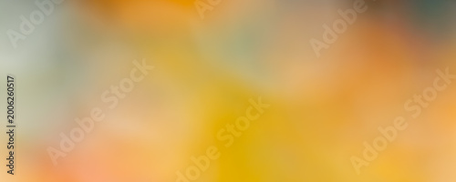 Abstract bokeh background with vibrant orange and yellow colors and blurry light spots. Dreamy soft focus texture for graphic design, web banners, and copy space.