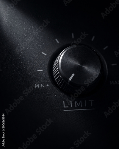 Silent control power not speaking dial knob limit minimal audio volume adjustment in dramatic low light creating moody industrial feeling