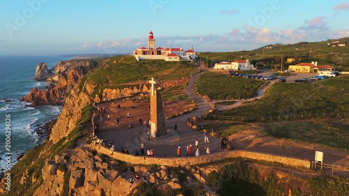 Cabo da Roca, Cape Roca, Cliffs and Atlantic Ocean at Sunset. Lighthouse and Cross. Portugal. Aerial View. Orbiting