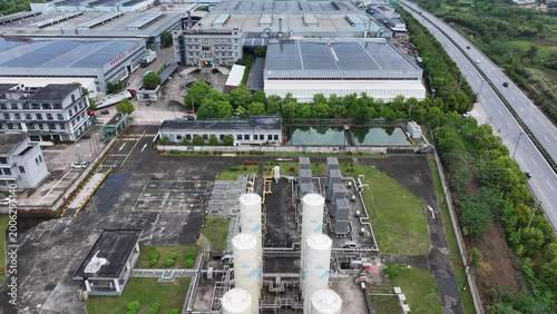Tablou pe pânză Aerial view of industrial park featuring storage tanks, factory buildings, and a