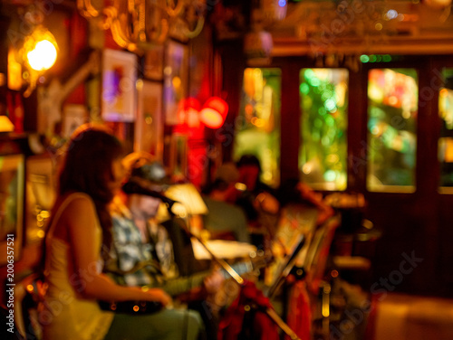 Blurred defocused live music jazz band performance inside cozy vintage bar with warm golden red bokeh ambiance nightlife
