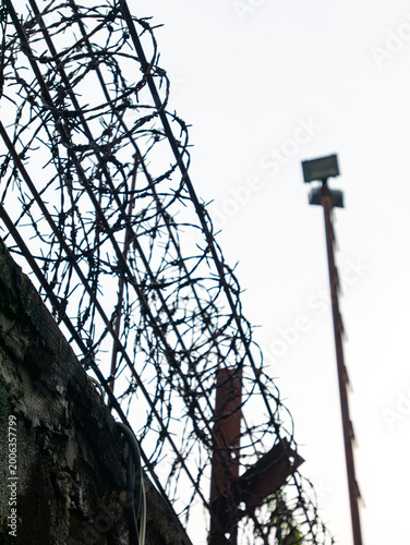 Принти на полотні Razor wire and barbed wire coil on top of concrete wall against grey sky with se