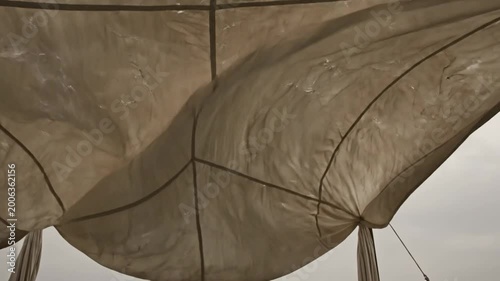 Low angle view of a draped fabric canopy with the overcast sky in the background.