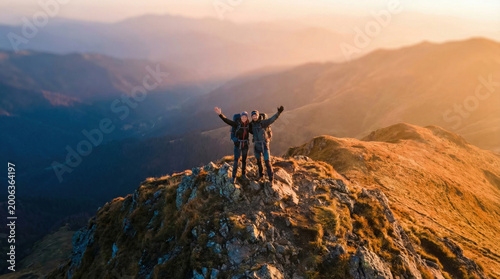 Two hikers, viewed from above, reach a mountain