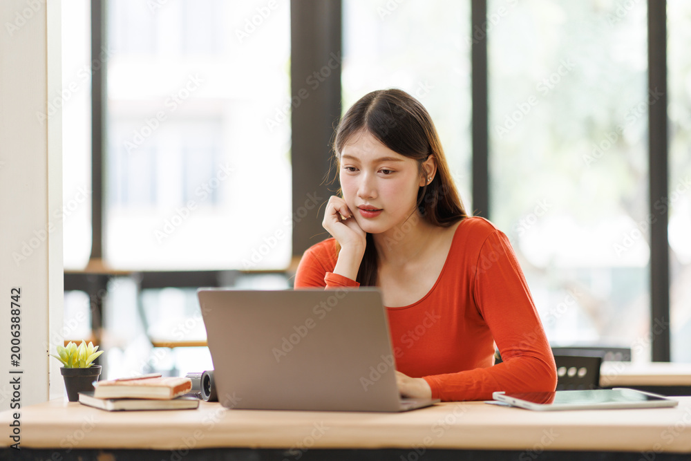 Obraz premium Asian woman concentrating on laptop for remote work or studying