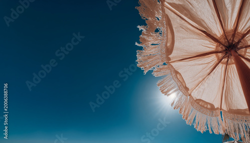 An upward-facing shot capturing the intricate texture of multiple thatched straw umbrellas on a beach, framed against a bright blue sky. This image perfectly conveys themes of summer vacation
