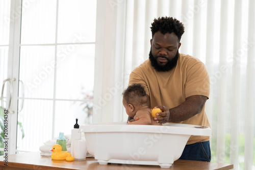 Fotografie Cute baby taking bath in tub of water at home