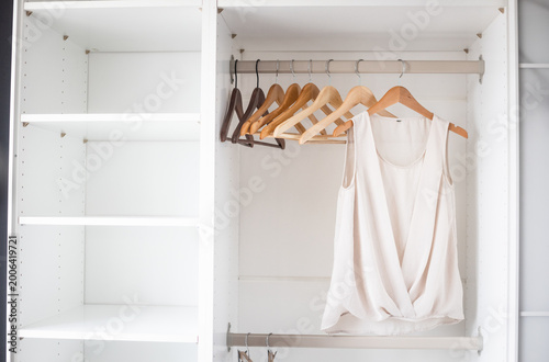 Tableau sur toile White shirts hanging neatly in closet, organized storage