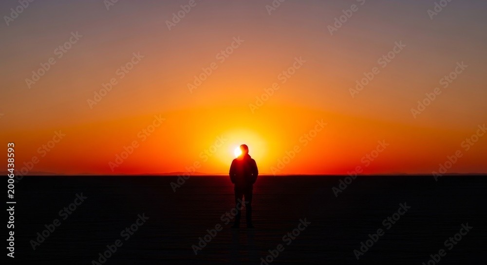 Fototapeta premium Person silhouetted against vibrant sunset sky