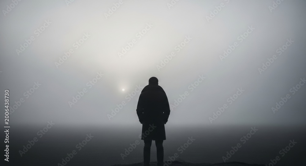 Obraz premium Person silhouetted in vast fog, looking out