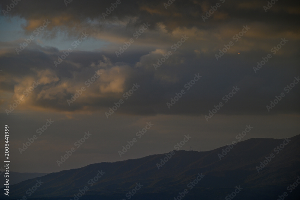 Obraz premium Dramatic storm clouds over mountain ridge at dusk