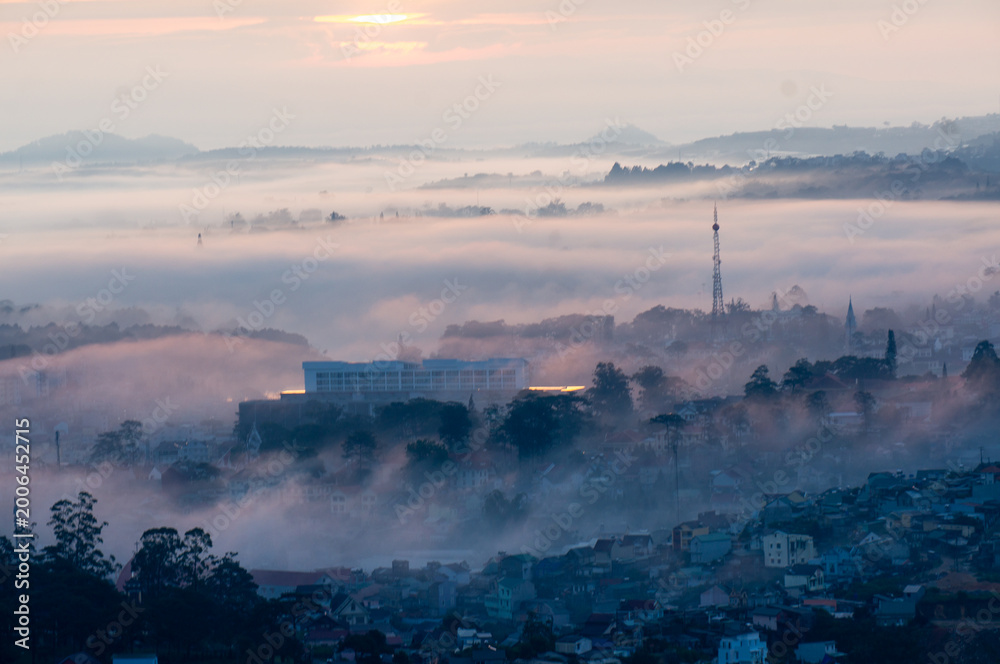 Fototapeta premium The view of Da Lat from Du Sinh Cemetery towards the city center. Da Lat on a morning shrouded in mist and early sunlight, a magical morning light. Beautiful Vietnamese scenery.