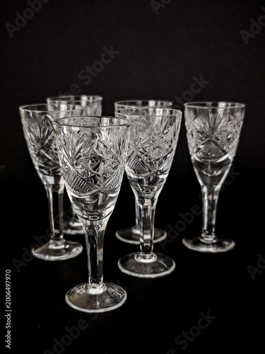 Set of vintage cut crystal wine glasses on a dark background, elegant decorative glassware with ornate patterns and reflective details