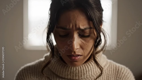 Woman wearing a beige turtleneck looking concerned and stressed with a troubled facial expression looking directly into the camera