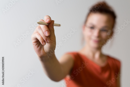 A woman writes with a penci...