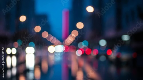 Urban bokeh with blue and orange street lights reflecting on road
