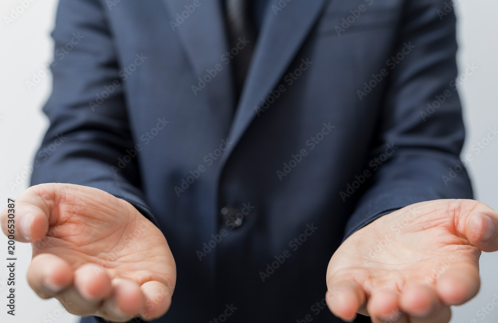 Fototapeta premium Businessman extending empty palms towards camera, concept of giving, offering, and trust.