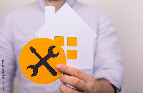 Hand holding house and tool...