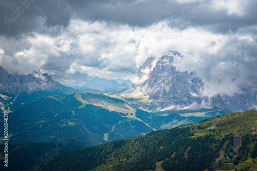 Ortisei, Val Gardena, Italy—alpine village in South Tyrol with distant Dolomite peaks rising above lush green valleys. Scenic Alps landscape with clear mountain views and travel appeal.