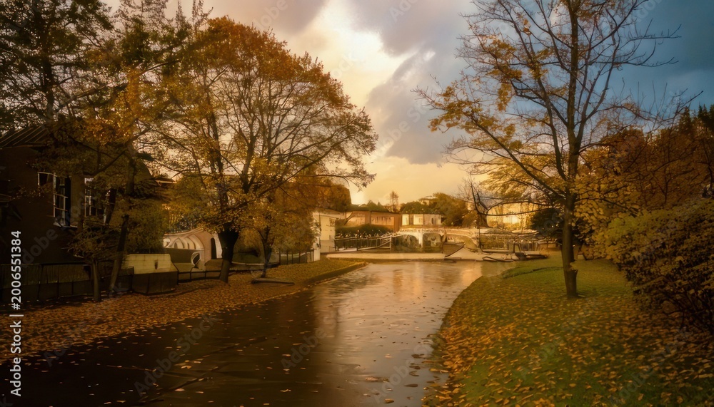 Obraz premium Serene Autumn Canal Reflecting Golden Trees and Cloudy Sky.